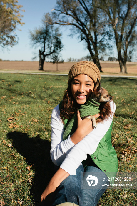 Smiling woman hugging dog outdoors