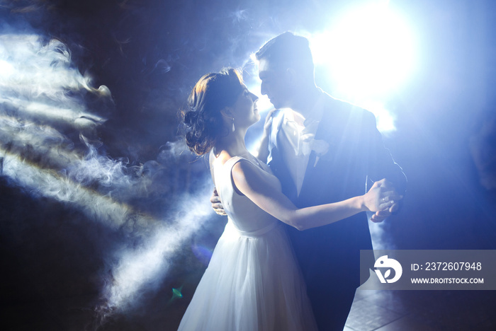 First wedding dance of newlywed. Wedding couple dancing in the darkness. Groom holds brides hand da