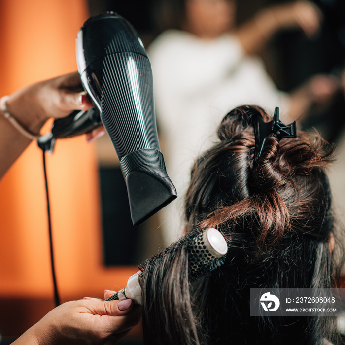 Hairdresser Curling Woman’s Hair.