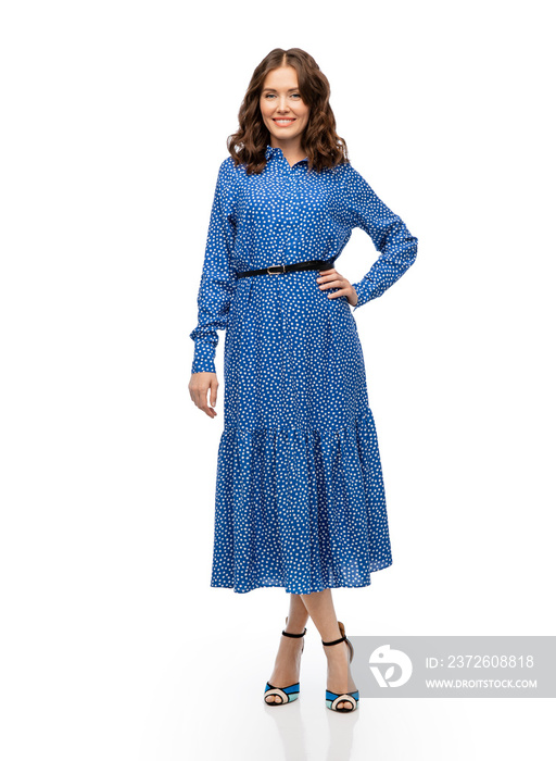 fashion, style and people concept - happy smiling beautiful young woman posing in blue dress over wh