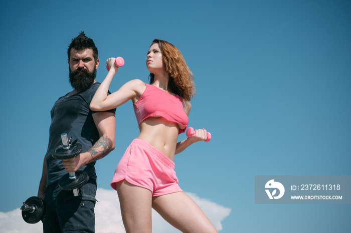 bearded man and woman with fit belly. dumbbell lifting. sport and fitness. sporty couple training ou