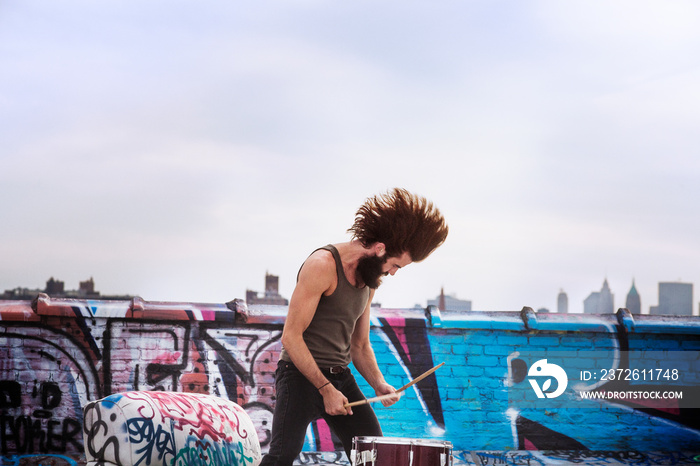 Young man playing drums outdoors