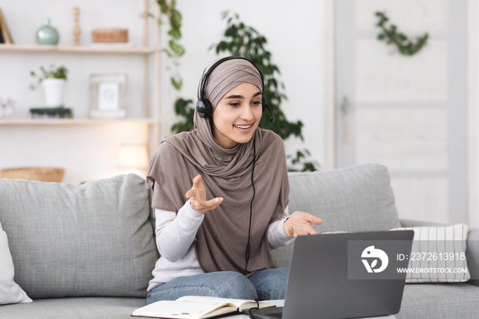 现代通讯。戴着头巾和耳机的穆斯林妇女正在进行视频通话