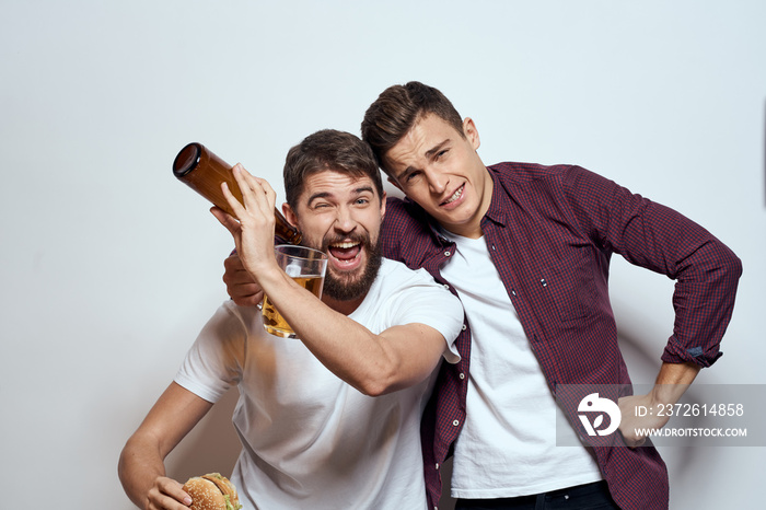 Two cheerful friends drinking beer drunk fun lifestyle communication light background