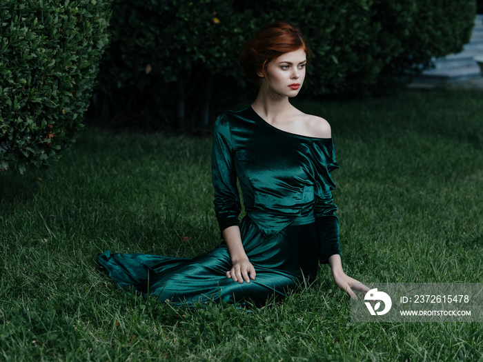 绿色连衣裙的女人躺在花园装饰的大自然中
