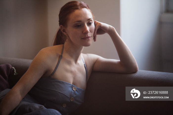 Mid-adult woman sitting on sofa