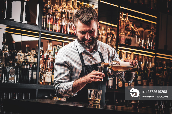 Diligent happy barman is preparing alcoholic beverege for customer.