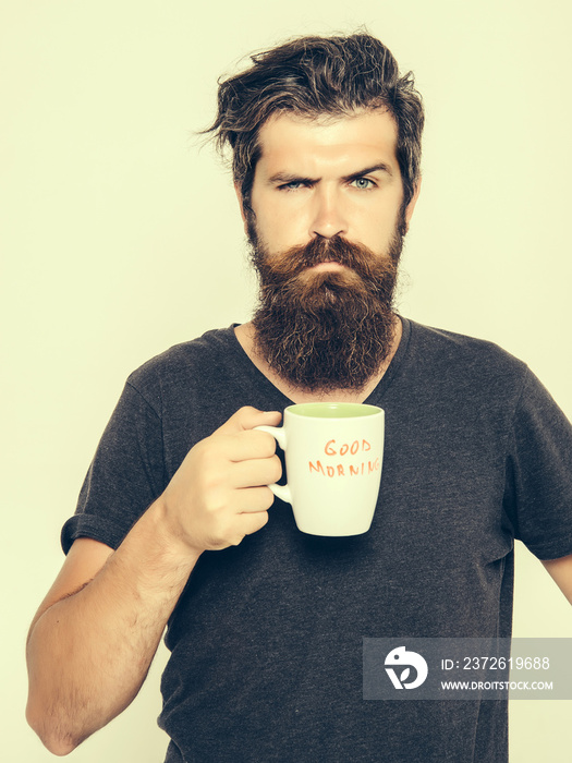 留着胡子的严肃男人，喝着咖啡或茶