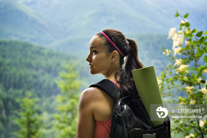 Rear view of woman with backpack and exercise mat