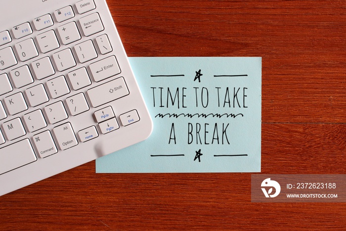 Top view image of keyboard and blue paper with text TIME TO TAKE A BREAK