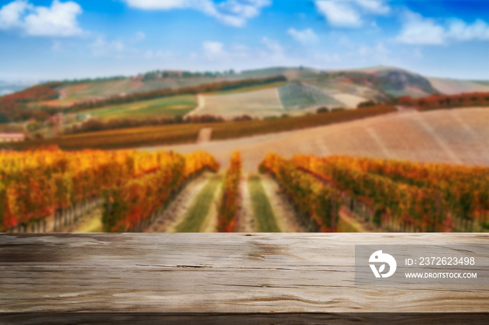 Brown wood table in autumn vineyard landscape with empty copy space on the table for product display