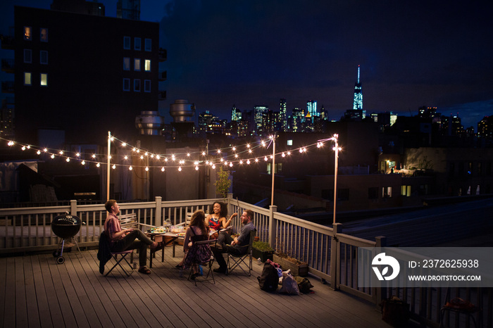 Group of friends sitting on roof terrace