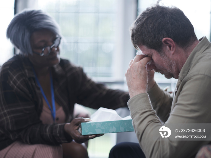 Therapist giving patient handkerchief in therapy session