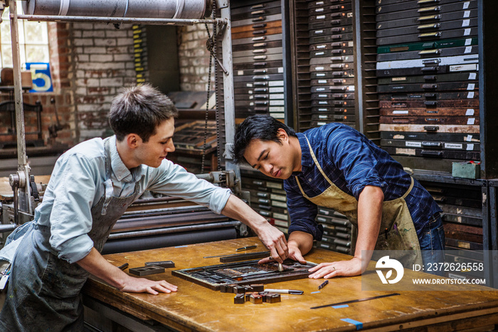 Craftsmen working with letterpress in workshop