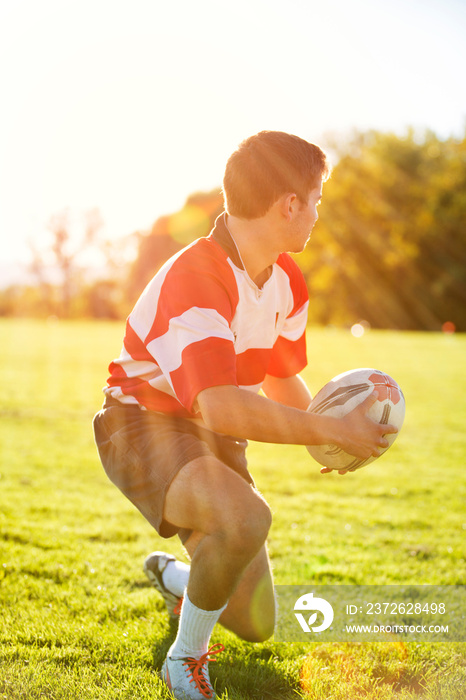 Young man playing rugby outdoors