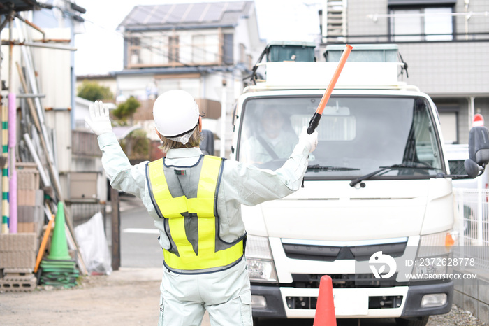 トラック（車両）を誘導する交通誘導員の男性