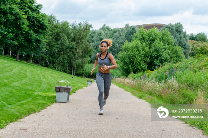 Woman with headphones jogging in nature