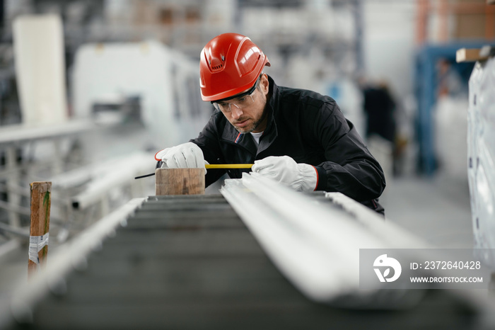 Portrait of worker in factory. Young handsome man working in factory.