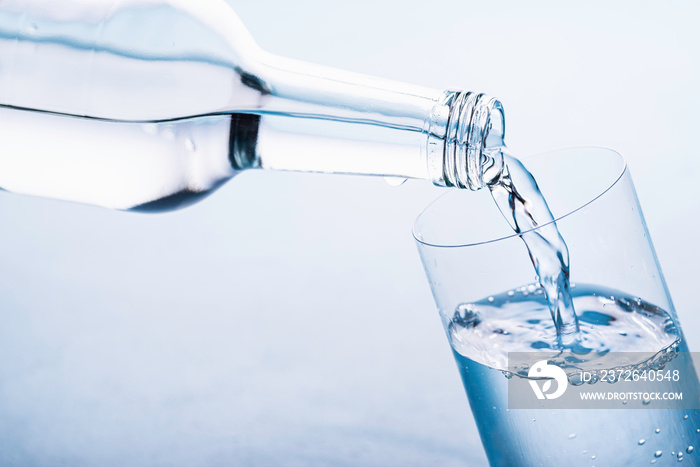 Pouring clear water in glass. Water glass bottle