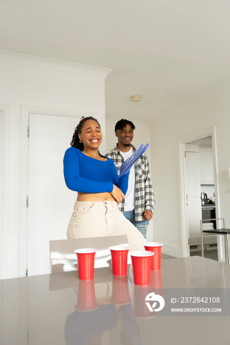 Friends�playing beer pong at home party