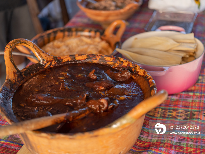 Traditional clay pots with mole, Mexican red rice, and tamales