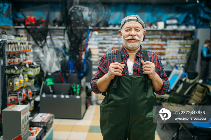 Fisherman tries on rubber jumpsuit in fishing shop