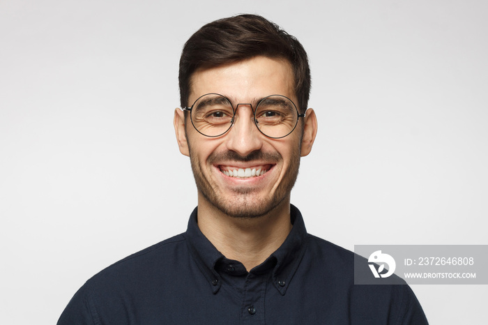 Portrait of handsome business man laughing, isolated on gray background