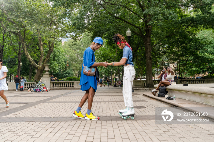 USA, Young man and woman with roller skates in park