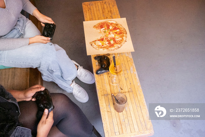 Women eating and drinking while playing in video games at pub