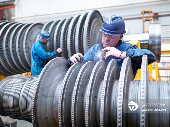 Engineers inspecting turbine during power station outage, portrait