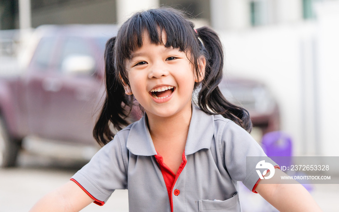 快乐的亚洲小女孩露出门牙，笑容满面：健康快乐有趣