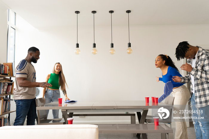 Friends�playing beer pong at home party