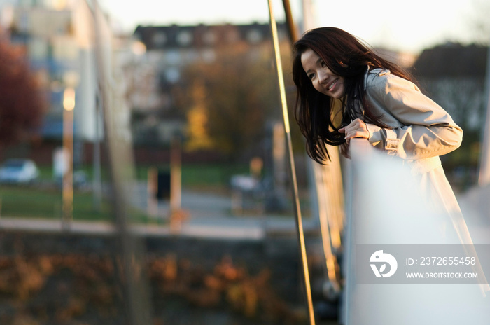 Woman leaning over bridge railing