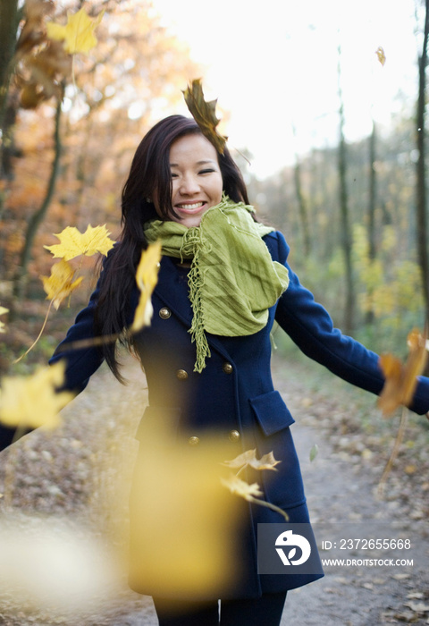 Woman playing in autumn leaves