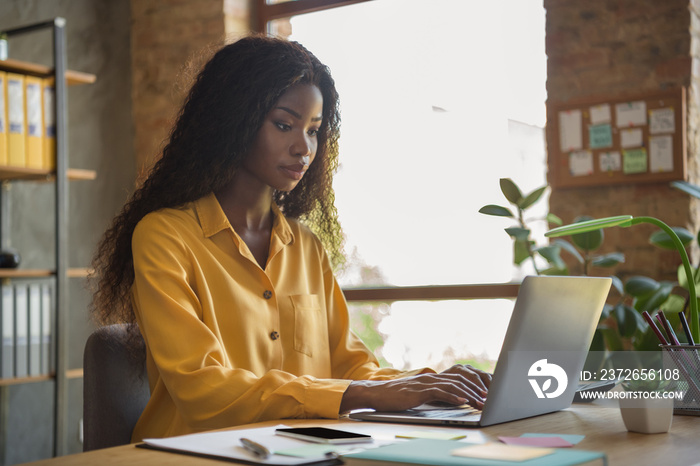 Profile side photo of serious dark skin brunette businesswoman typing computer office desk employee 