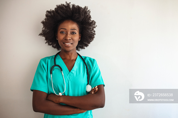 Friendly nurse with stethoscope isolated on grey. Smiling female healthcare professional looks at th