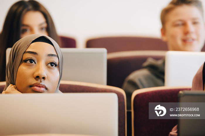 Serious male and female classmates listening in university lectures