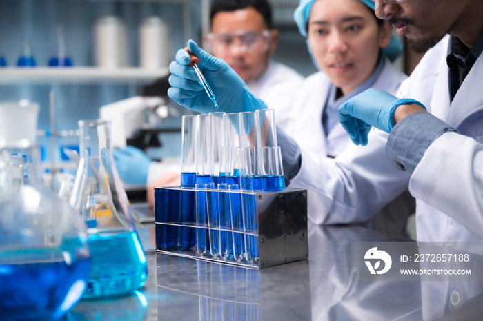 asian scientist hold a test tube filled with liquid in the laboratory