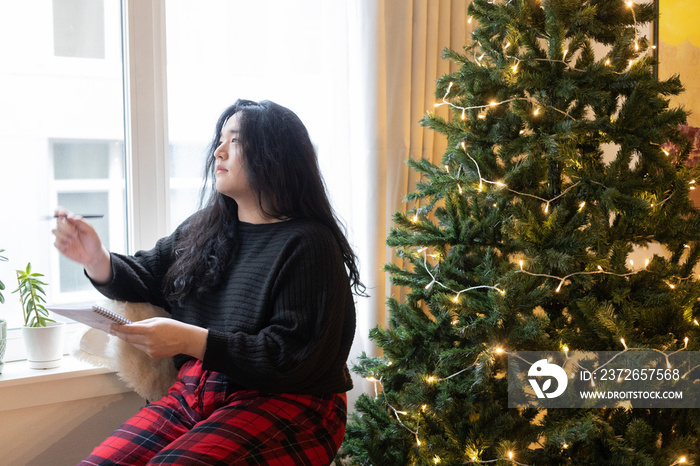 Asian American trans woman decorating for the holidays.