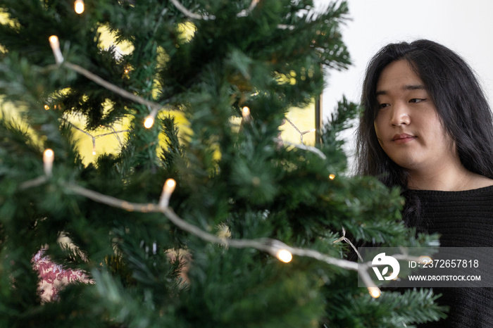 Asian American trans woman decorating for the holidays.