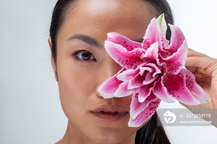 Close-up of woman holding white and�purple lily flower