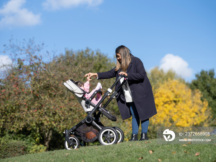Mother walking with daughter with Down syndrome in stroller