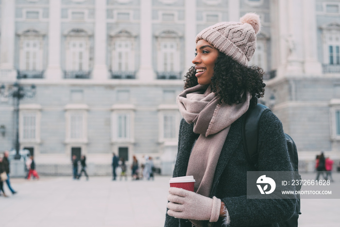 。冬天，年轻的黑人妇女在马德里街头闲逛，喝着咖啡