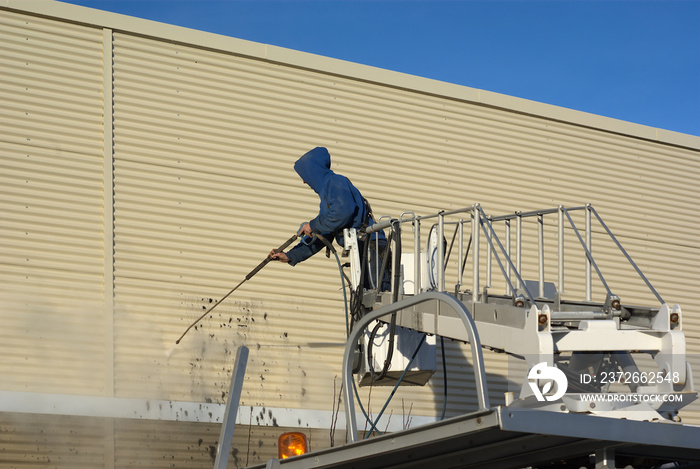 Pressure water jet to clean the graffiti on a wall