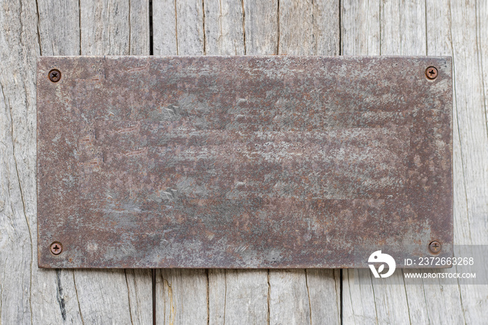 Rusted metal plates on the old wooden background