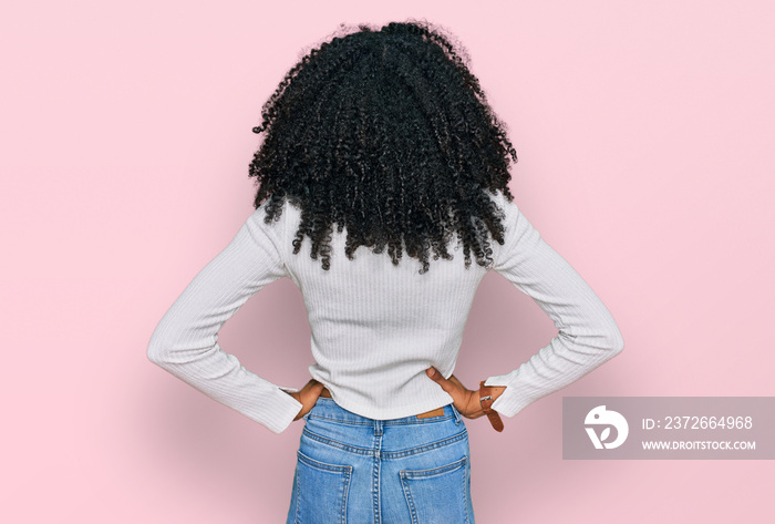 Young african american girl wearing casual clothes standing backwards looking away with arms on body