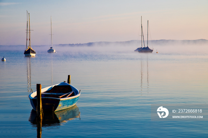 Morgendliche Seelandscahft mit Booten im Nebel