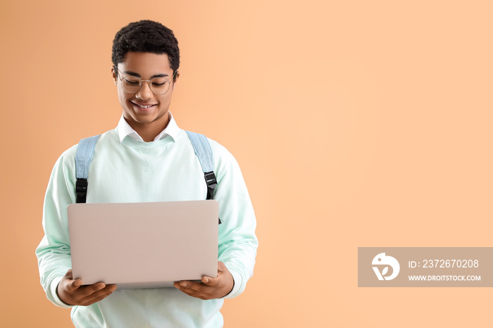 男非裔美国学生，彩色背景带现代笔记本电脑