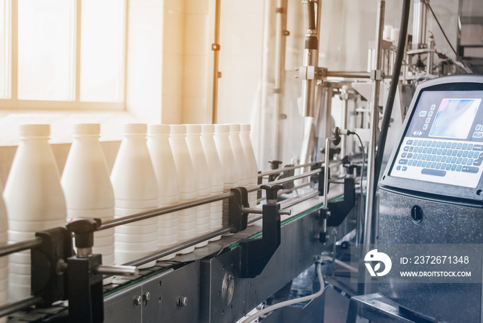 White plastic bottles with dairy product on the production line. Bottled on conveyor.