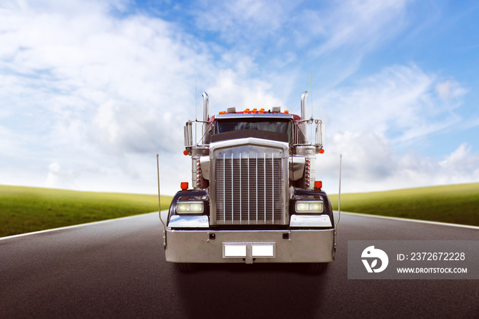 Truck driving on country road against blue sky